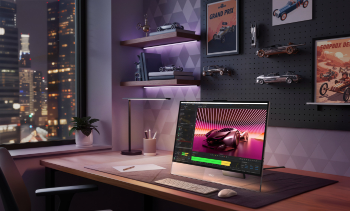 The Yoga AIO i Aura Edition computer is turned on and sits on a desk.